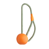 An orange and green Beco Slinger Ball attached to a green strap, designed for pet carriers.
