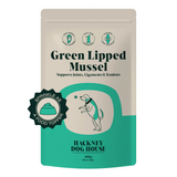 A package of Hackney Dog House Green Lipped Mussel Powder for Dogs in a beige and teal container with a graphic of a dog and text indicating the product supports joints, tendons & ligaments.