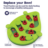 Green Nina Ottosson Buggin' Out cat puzzle with pegs, leaves, and treat compartments for interactive play.