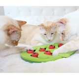 Green Nina Ottosson Buggin' Out cat puzzle with pegs, leaves, and treat compartments for interactive play.